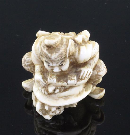 A Japanese walrus ivory netsuke of Shoki crushing two oni, signed Gyokuzan, Meiji period, 3.8cm